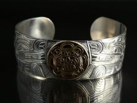 Native Wolves carved into a .925 Silver Bracelet with 14k Gold Sun by William Cook
